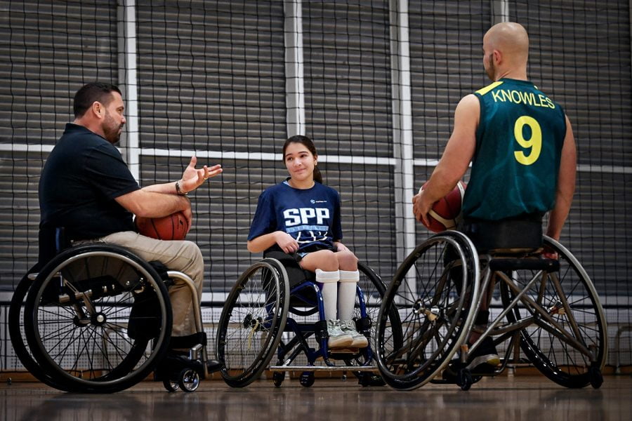 Grant Mizens and Tristan Knowles providing advice to a young wheelchair basketballer