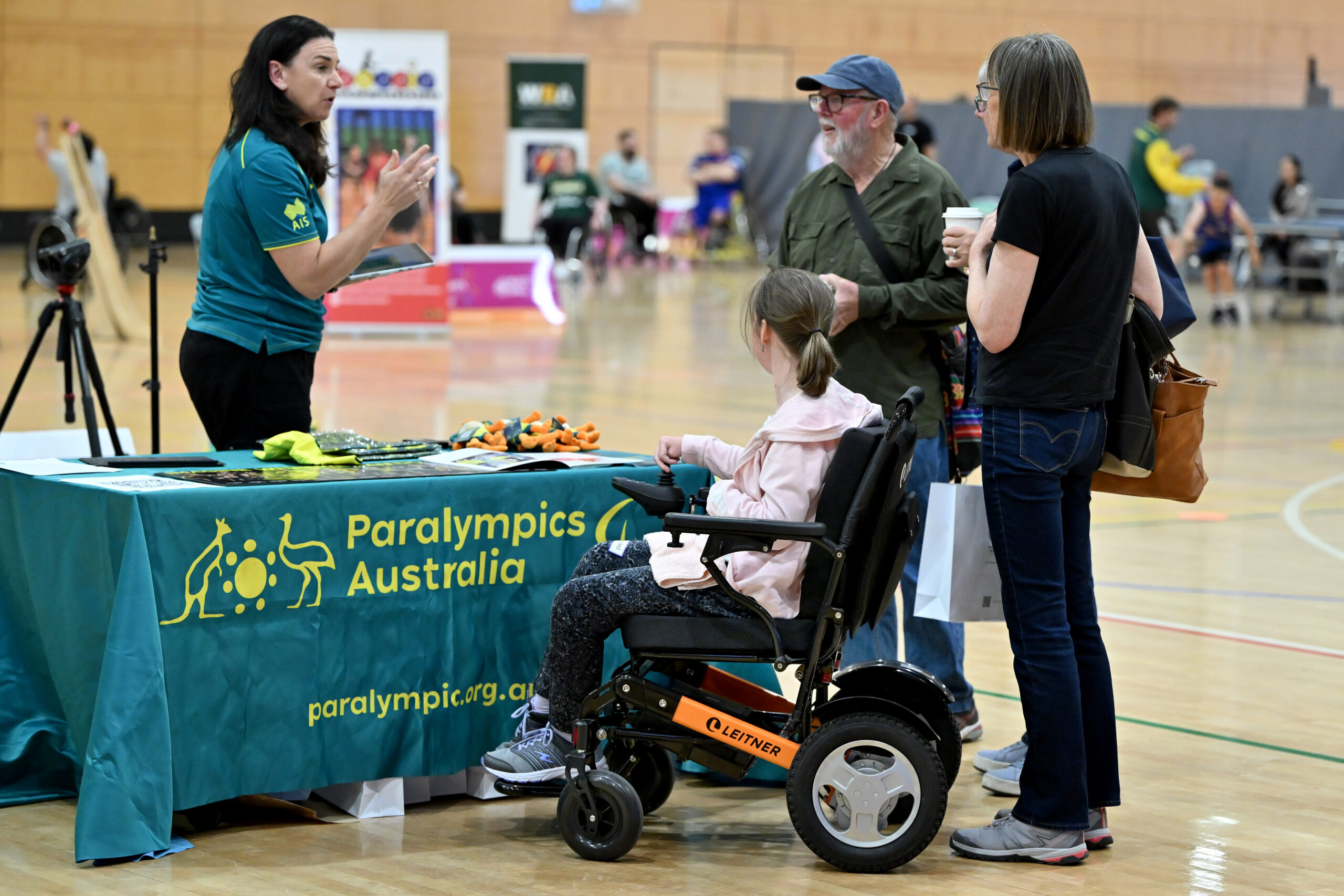 Paralympics Australia representative speaking to a wheelchair user and guardians
