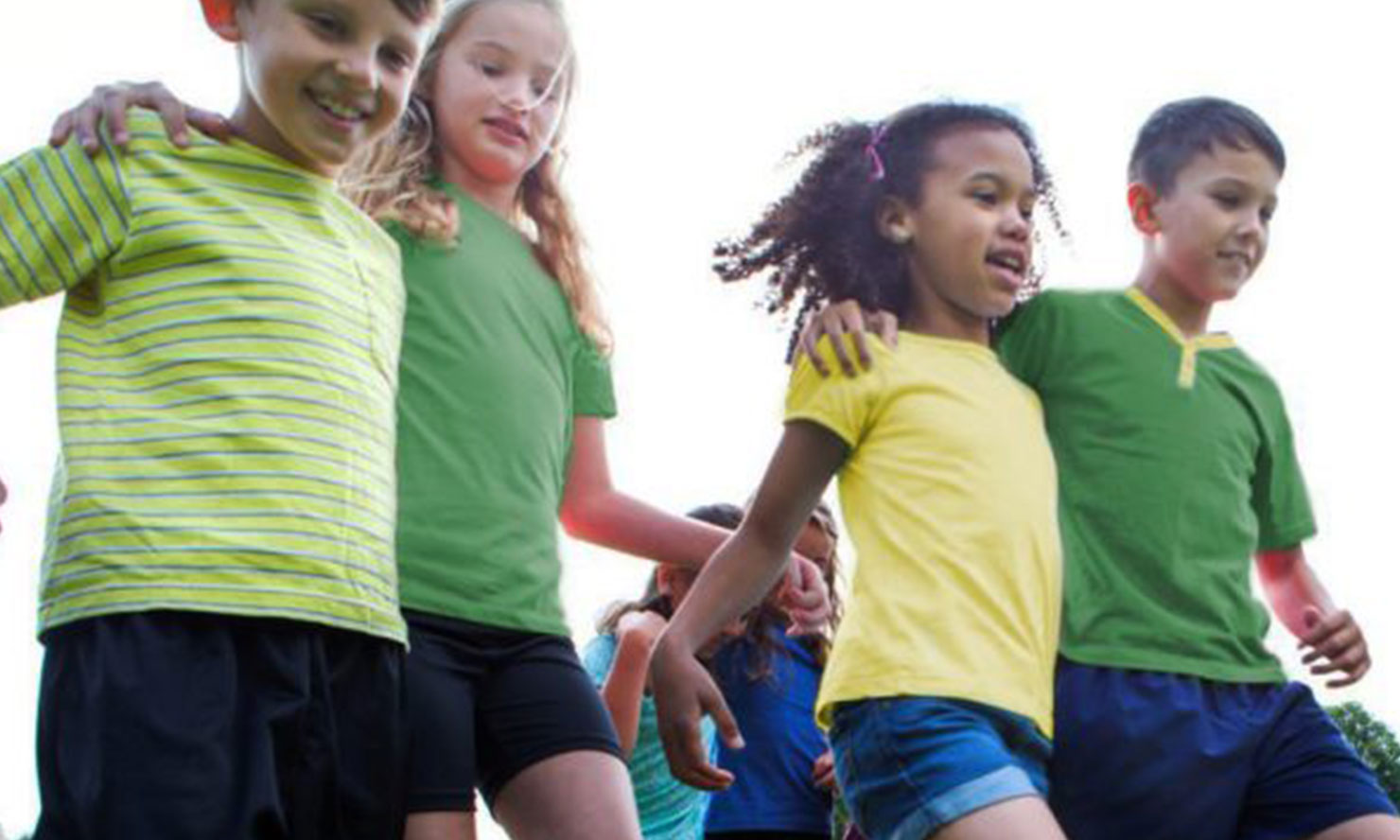 Kids in green and gold shirts playing