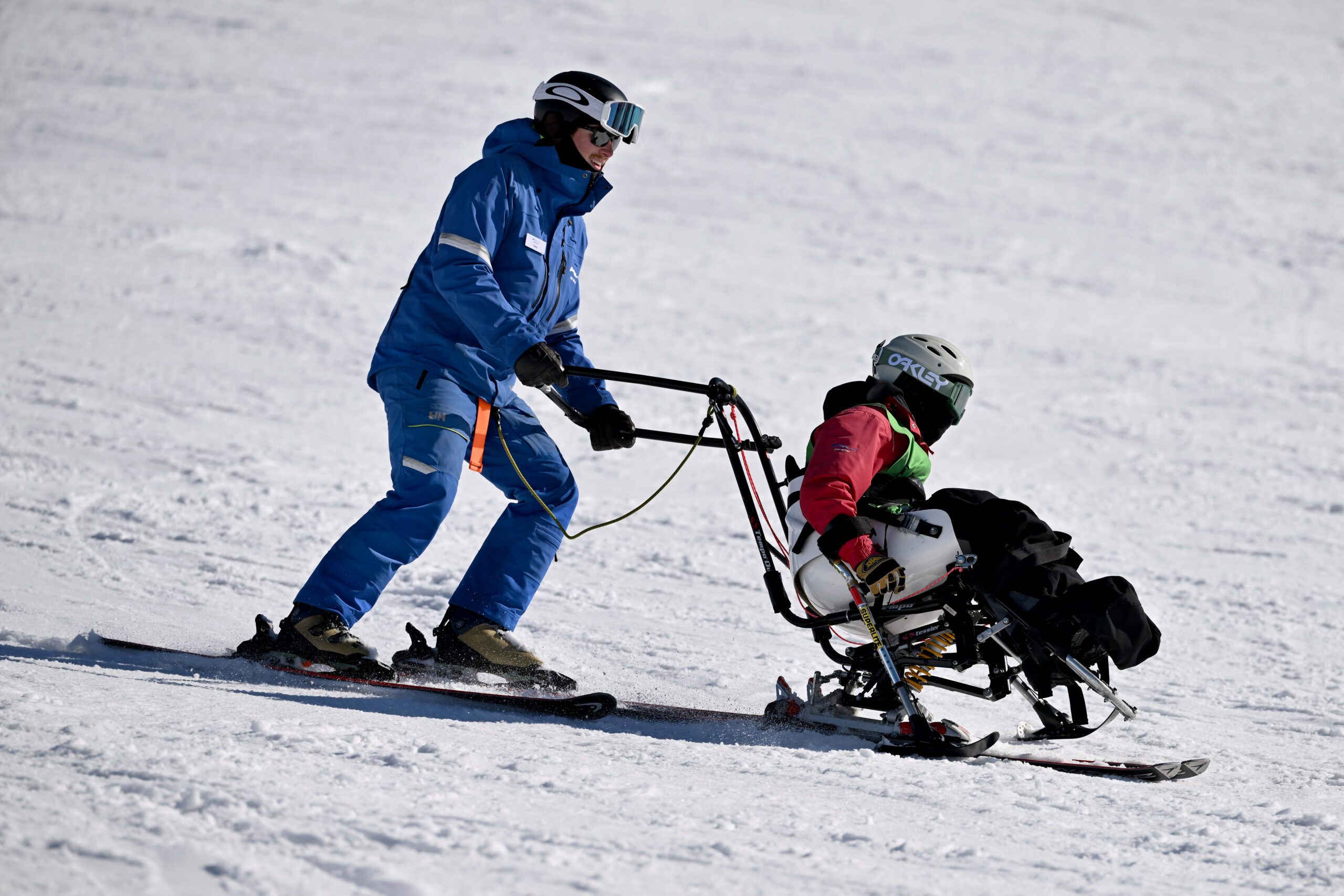 A skier pushing someone in a sit ski