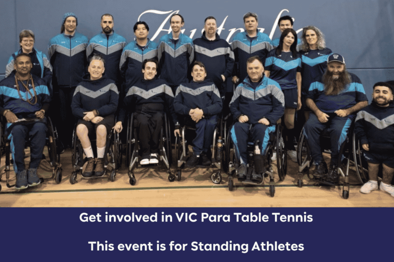 Group photo of para table tennis players in blue-gray jackets, several in wheelchairs, posing in a gym.