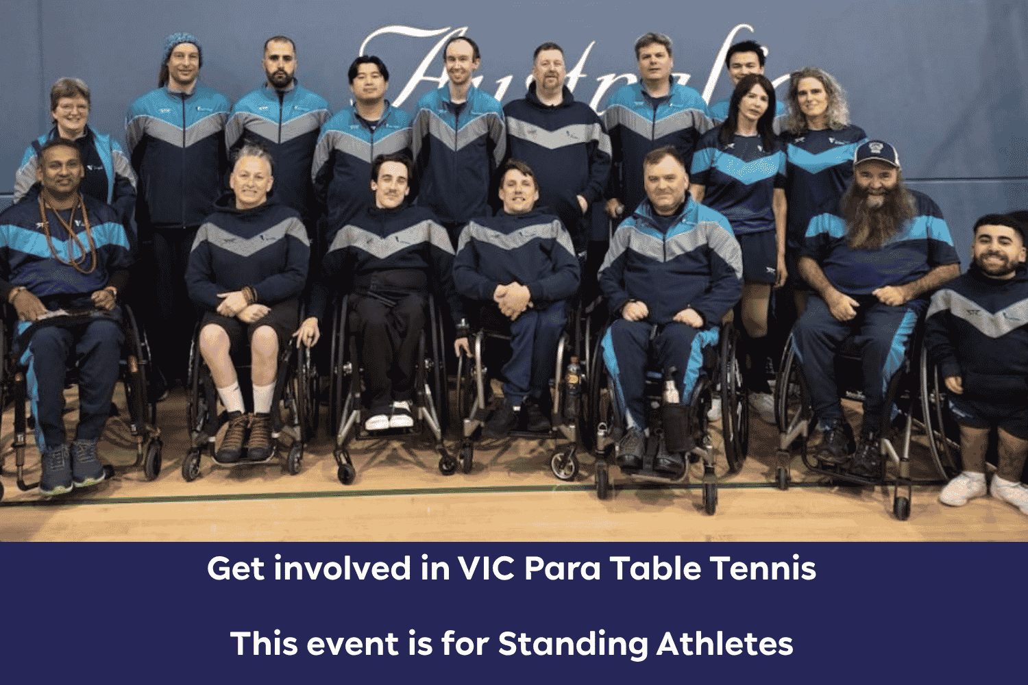 Group photo of para table tennis players in blue-gray jackets, several in wheelchairs, posing in a gym.
