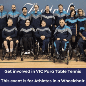 Group photo of wheelchair athletes in matching blue and gray uniforms, posing in a gym for a wheelchair table tennis team event.