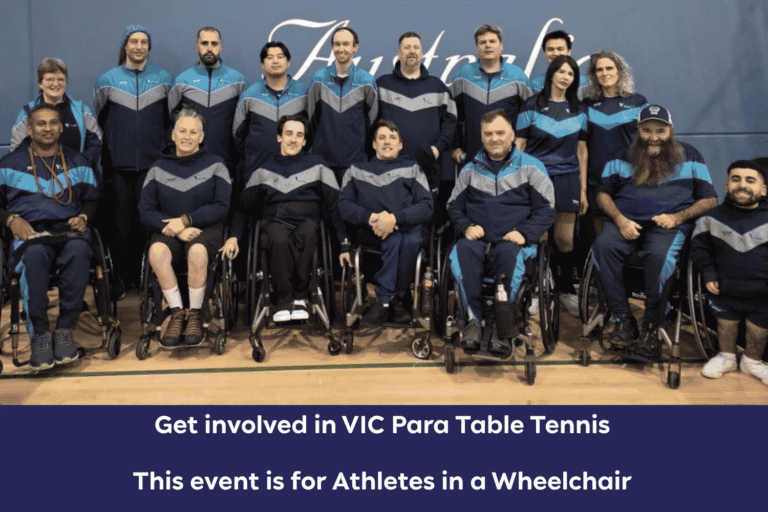 Group photo of wheelchair athletes in matching blue and gray uniforms, posing in a gym for a wheelchair table tennis team event.